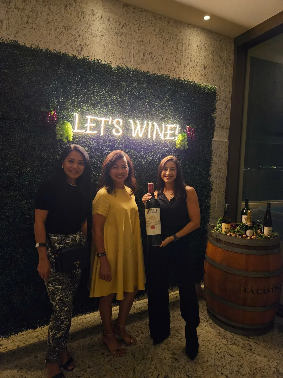 Three hosts in front of a “Let’s Wine” neon sign at The Tsubaki Tower